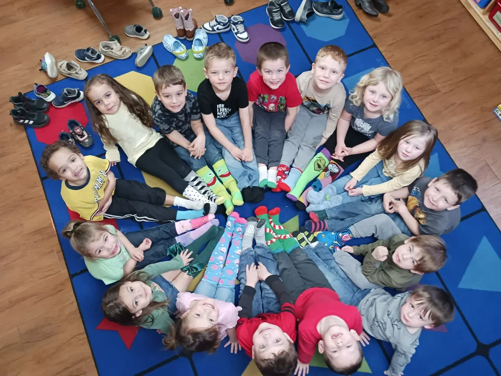 Children gathered in a circle looking up at Playhouse Children's Center