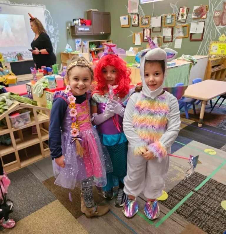 Children dressed up in costumes smile at Learning Tree
