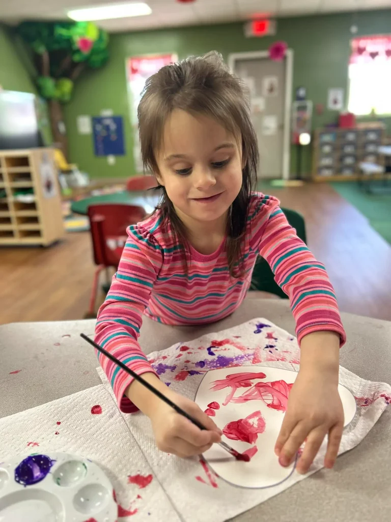 A child paints a heart at Playhouse Children's Center.