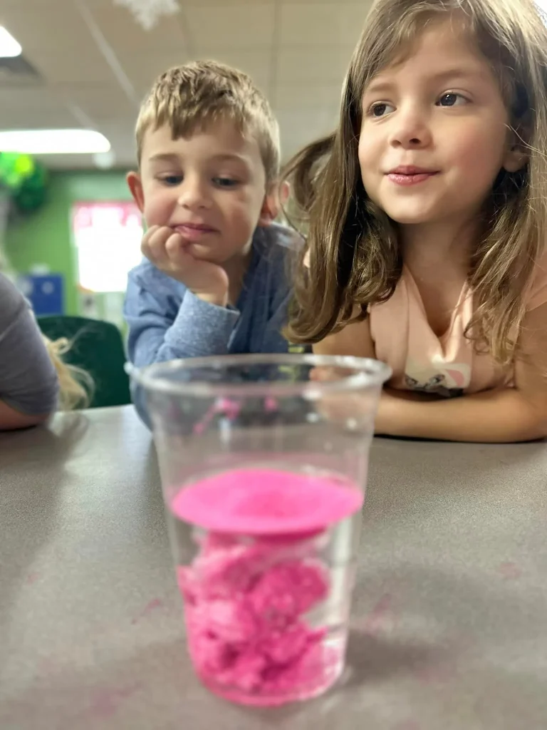 Children at a table look at a STEM project they made at Playhouse Children's Center