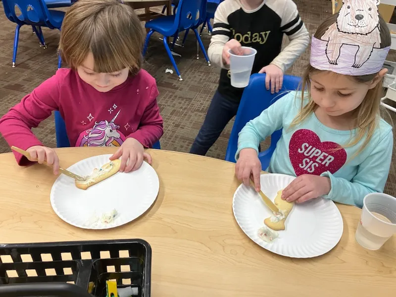 Children at Victory Elementary spread icing on cookies