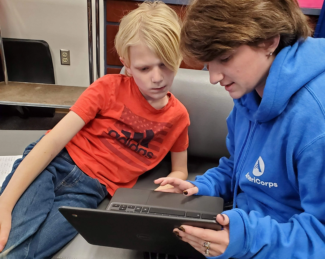 An AmeriCorps member teaching a youth